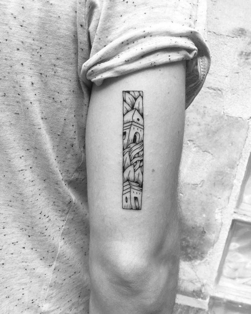 A rectangular tattoo containing a scenery of towers and leaves