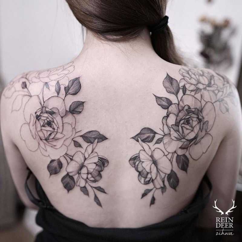 Matching illustrative tattoos on the shoulder blades