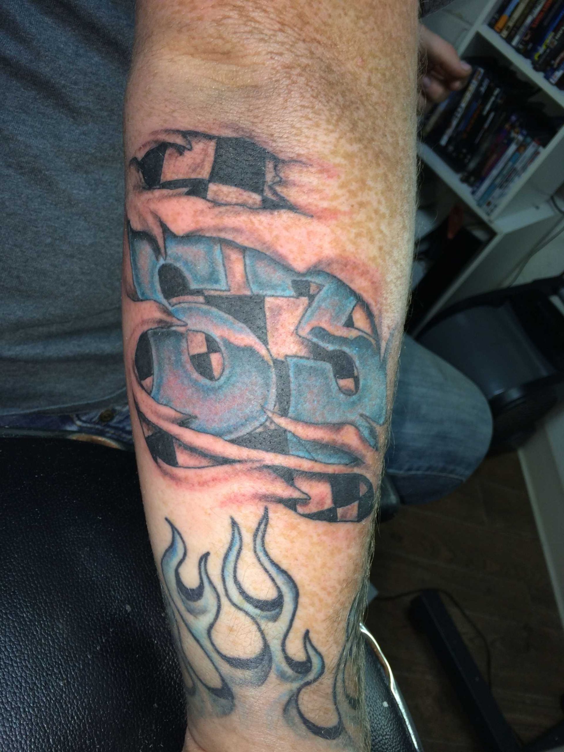 Race car number  in torn flesh tattoo done by Ricky Garza in