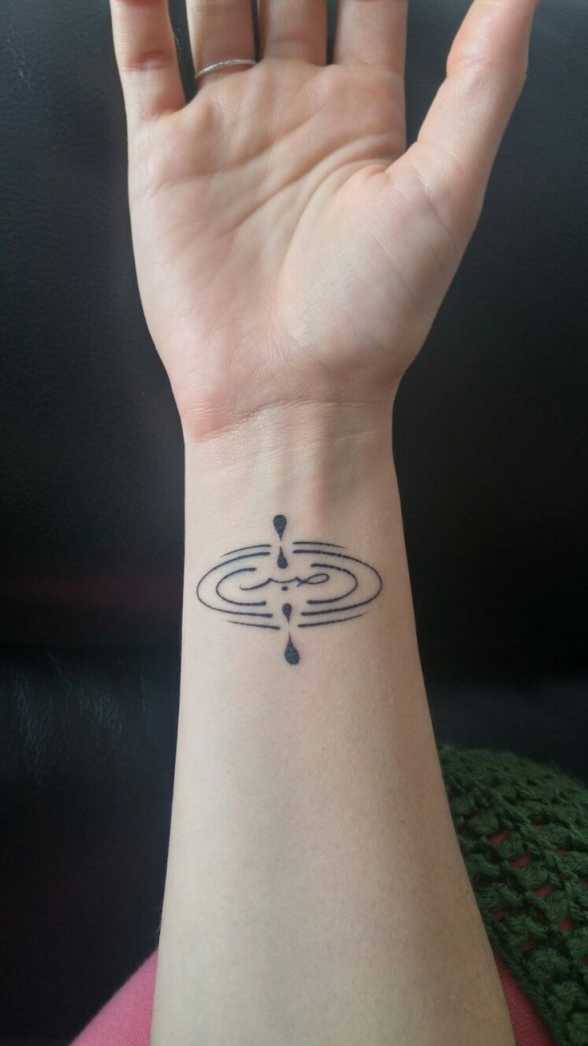 Tattoo of the symbol for mindfulness, with the Arabic word for